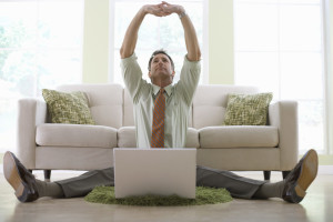 Businessman Stretching While Working on His Laptop